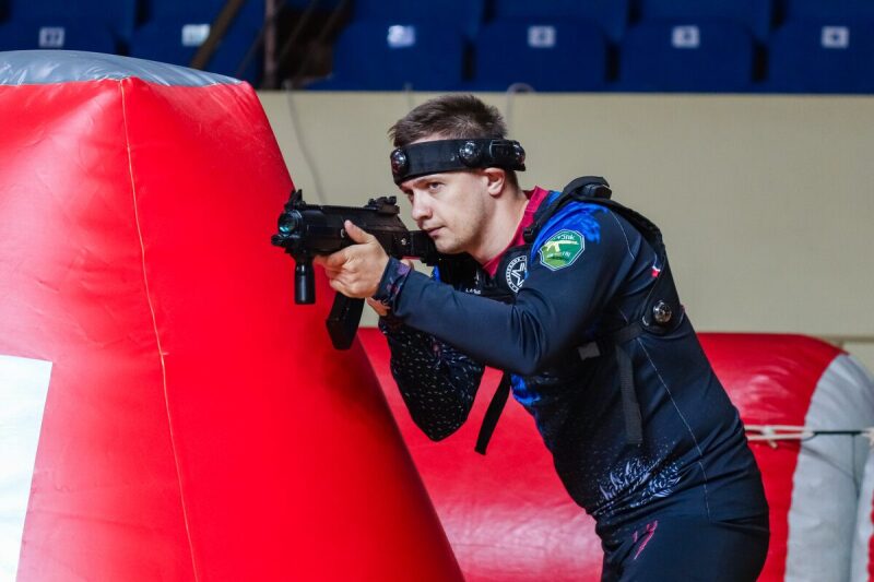 Боец LASERWAR в прицеле у красного надувного препятствия.